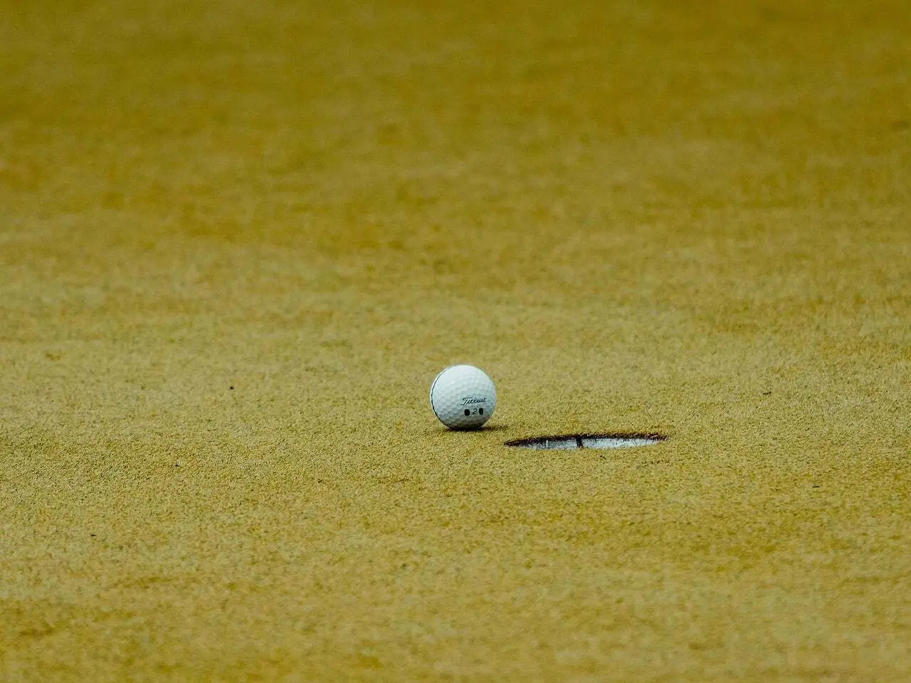 Golfbold ved et hul på en green