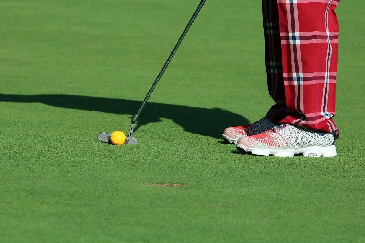 Golfspiller der putter på green